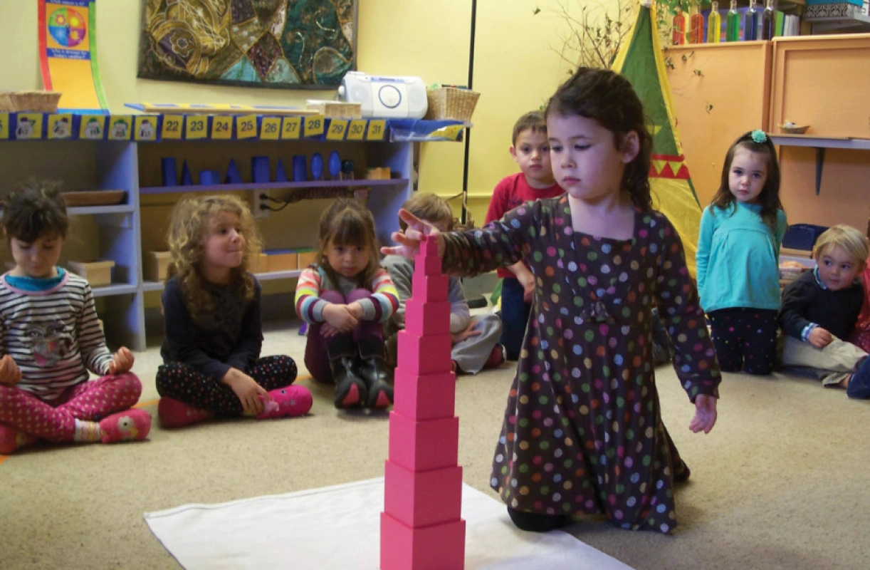 child holding a toy piece while kneeling down in the middle of other kids wellfleet ma
